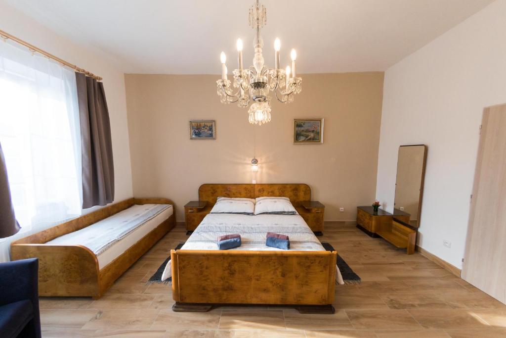 een slaapkamer met 2 bedden en een kroonluchter bij Stará Brusírna in Šatov
