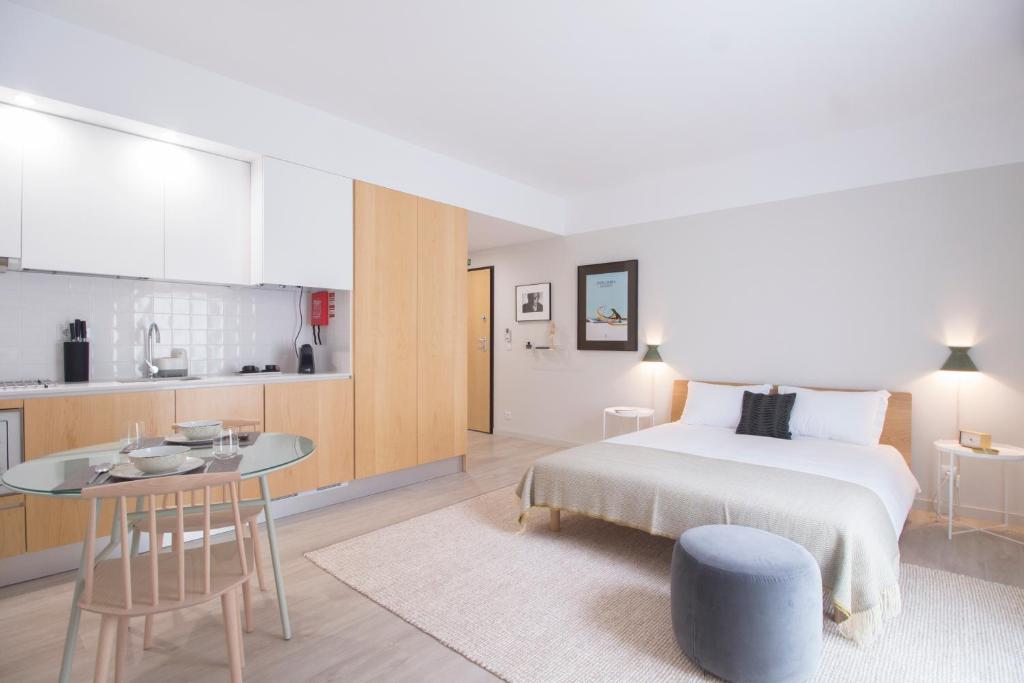 1 dormitorio con cama, mesa y cocina en Art Home Apartments I en Aveiro