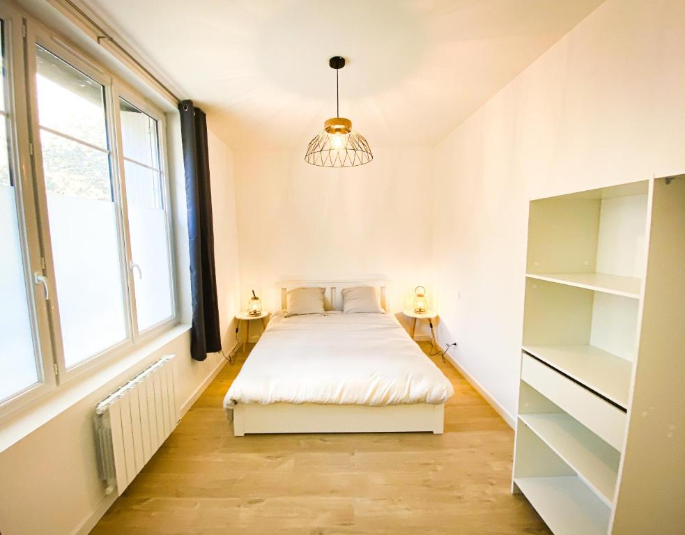 niewielka sypialnia z łóżkiem i żyrandolem w obiekcie APT bord de Mer, hypercentre Dinard, Parking prive w mieście Dinard
