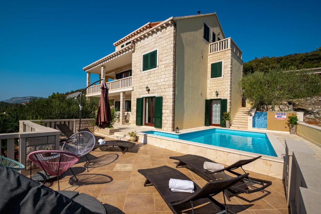 a villa with a swimming pool and patio furniture at Villa Ana in Korčula