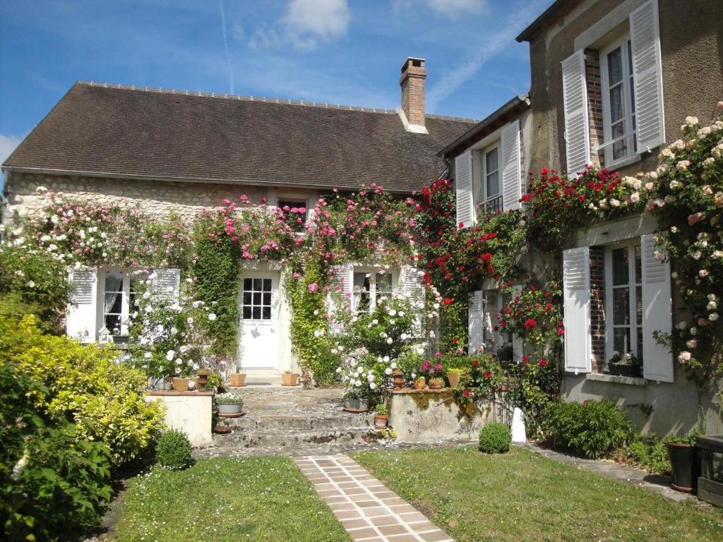 a house with flowers on the side of it at Maison Vérosia in Saint-Loup-de Naud