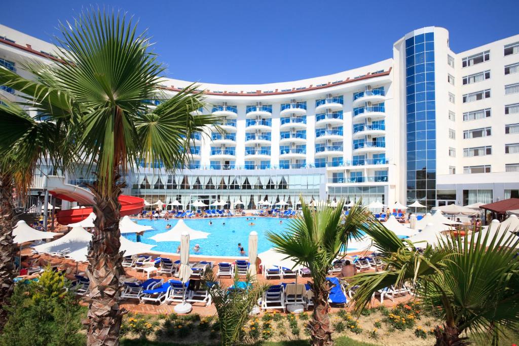 un hotel con piscina e palme di fronte di Narcia Resort Side - Ultra All Inclusive a Side