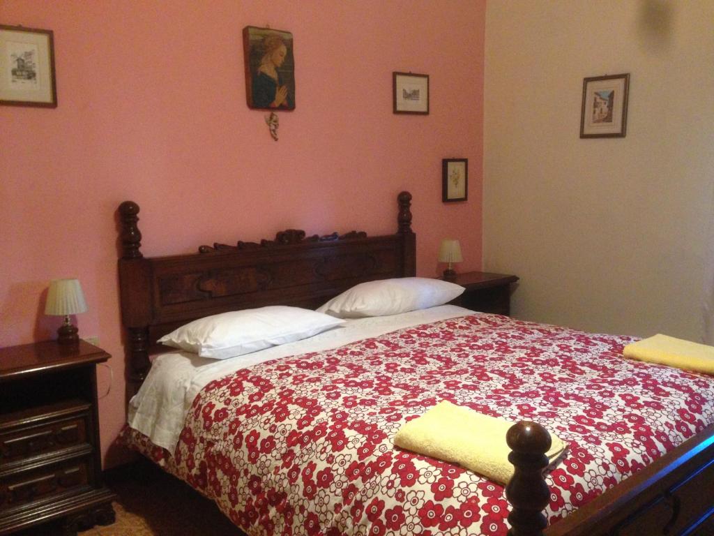 a bedroom with a bed with a red and white blanket at LA BARRIERA affittacamere in Florence