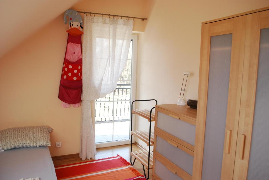 a bedroom with a bed and a window with a dresser at Dom wakacyjny Nasze morze in Kopalino