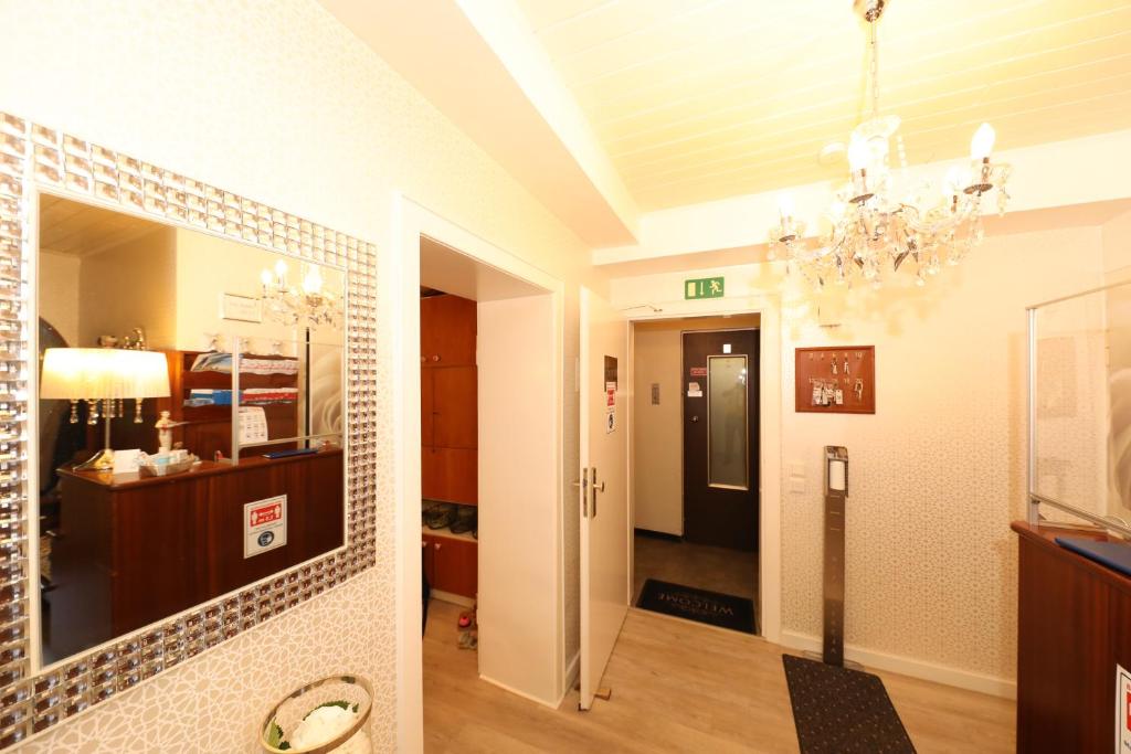 فندق ام إرينهوف في دوسلدورف: غرفة معيشة فيها ثريا وممر