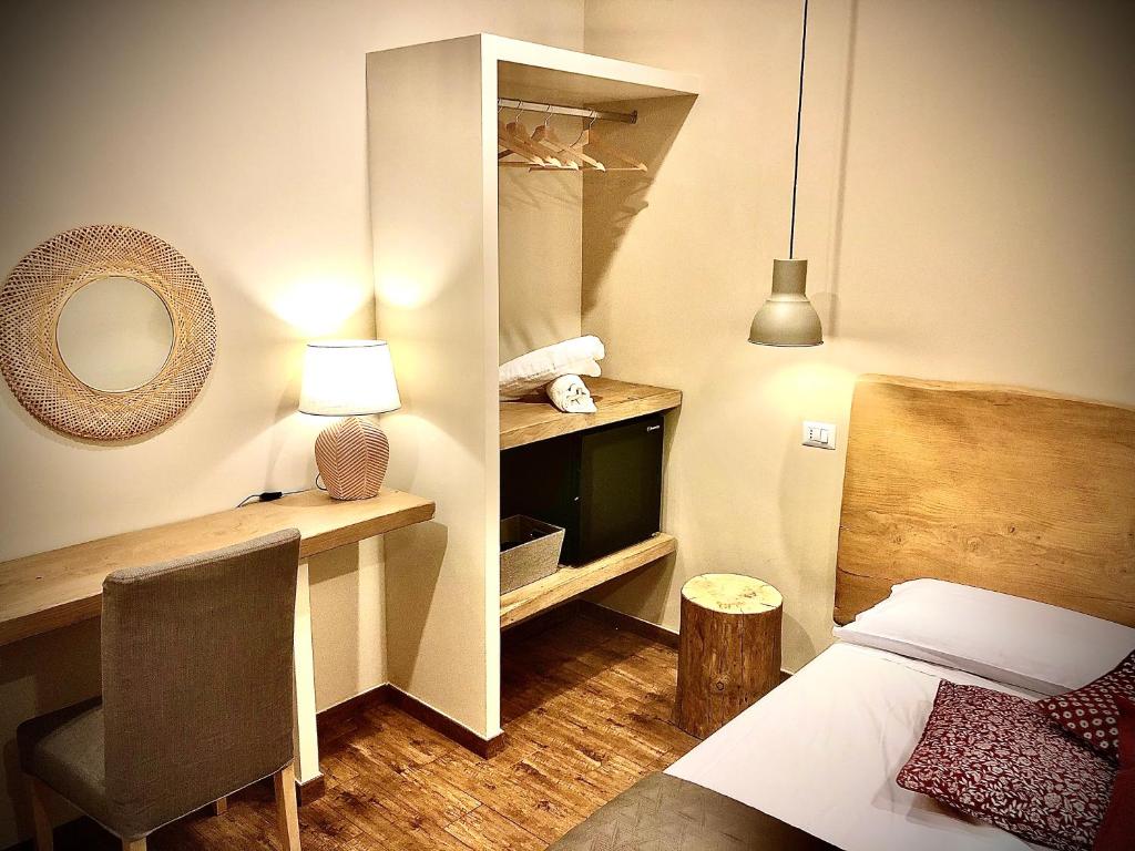 a bedroom with a bed and a desk and a mirror at B&B Il Vicolo in Caprarola
