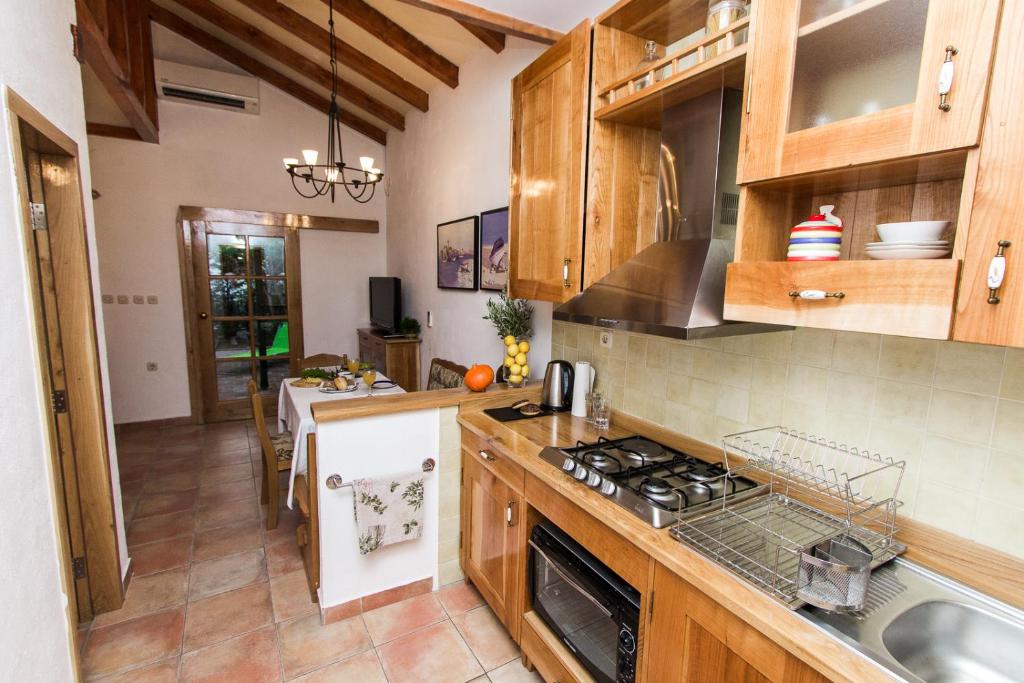a kitchen with wooden cabinets and a stove top oven at Beach House Jadrija in Šibenik