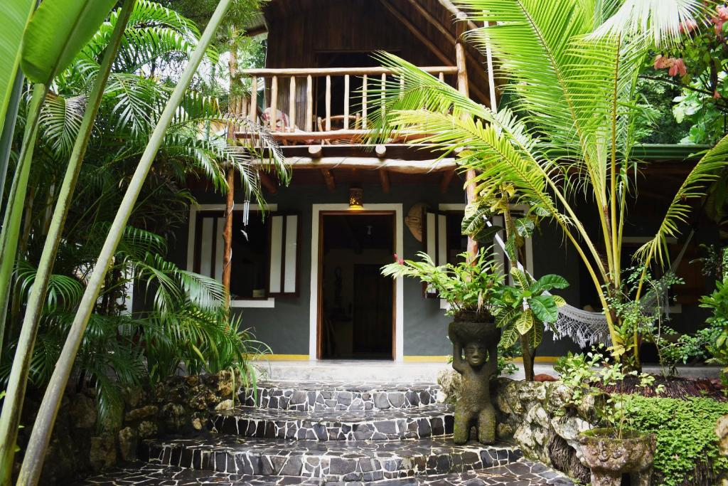 una casa con una escalera que conduce a la puerta principal en Pachamama Tropical Garden Lodge en Carmen