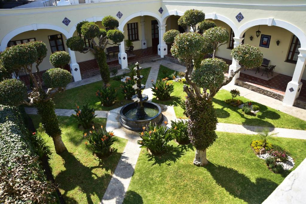 - une vue aérienne sur une cour avec une fontaine et des arbres dans l'établissement Hotel Boutique La Albertina, à San Martín Texmelucan de Labastida