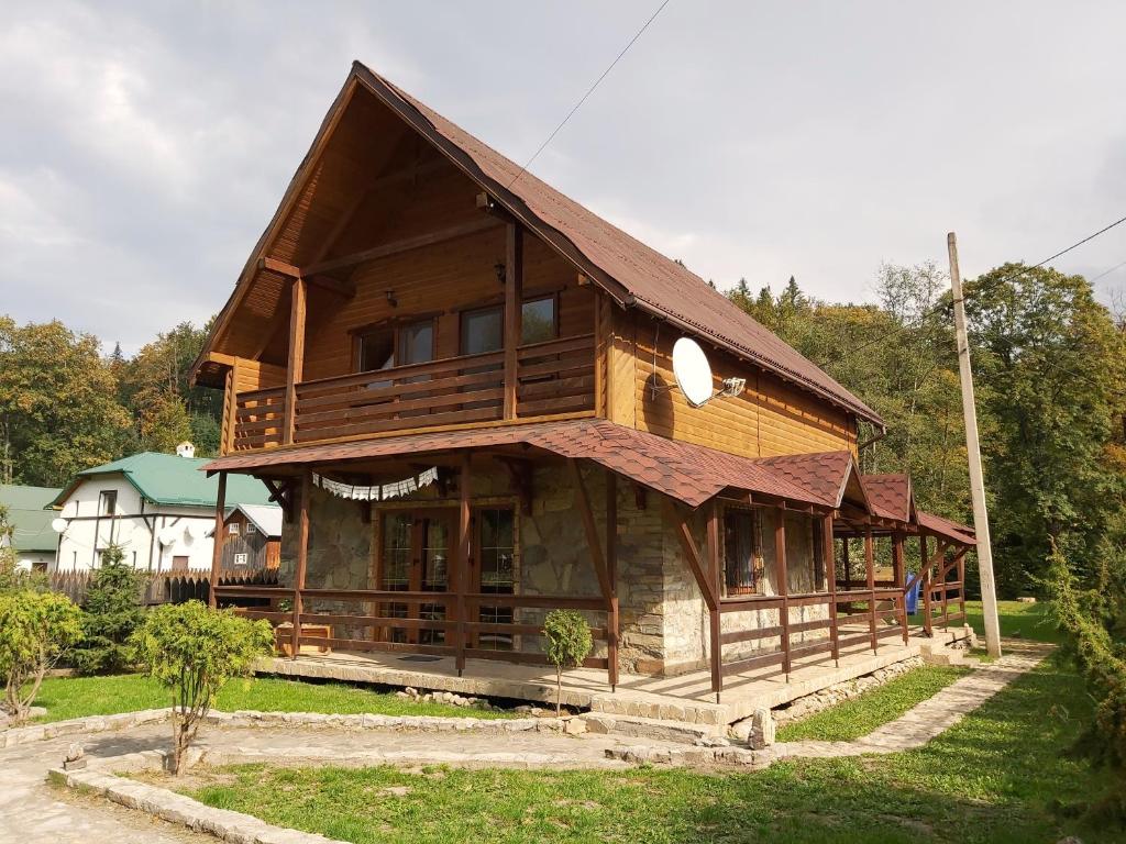 a large wooden house with a gambrel roof at Шале "Тиша" in Migovo