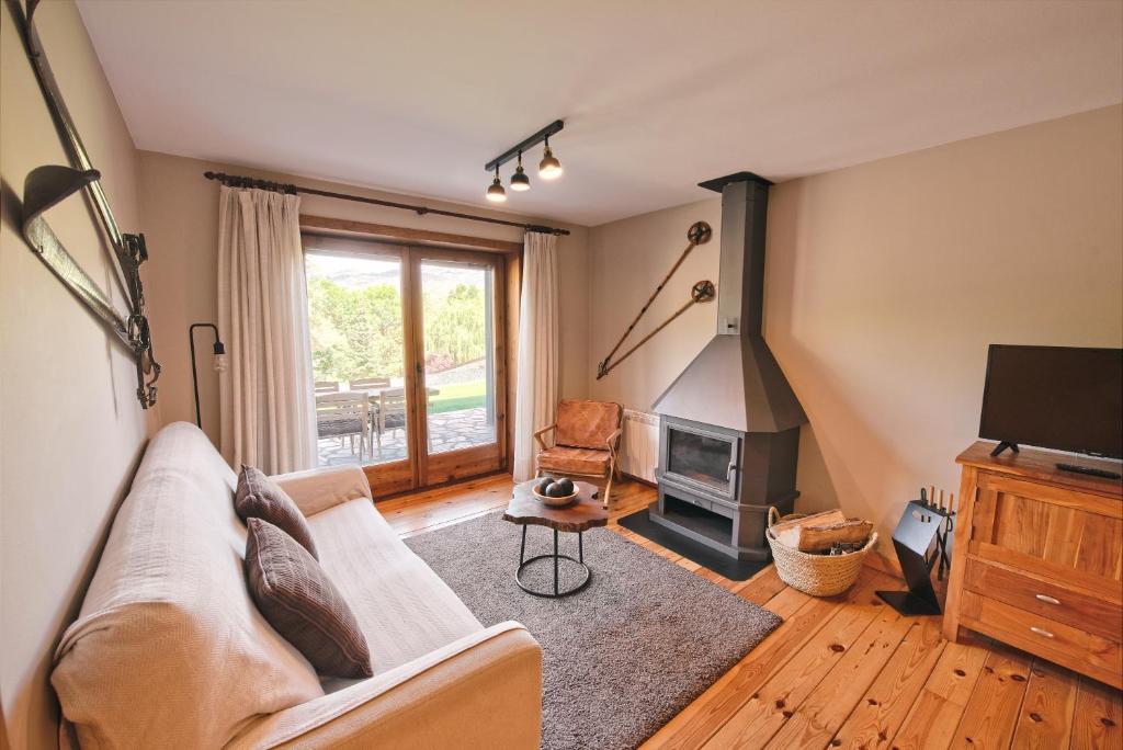 uma sala de estar com um sofá e uma lareira em Desconnectar Pi De Cerdanya em Bellver de Cerdanya
