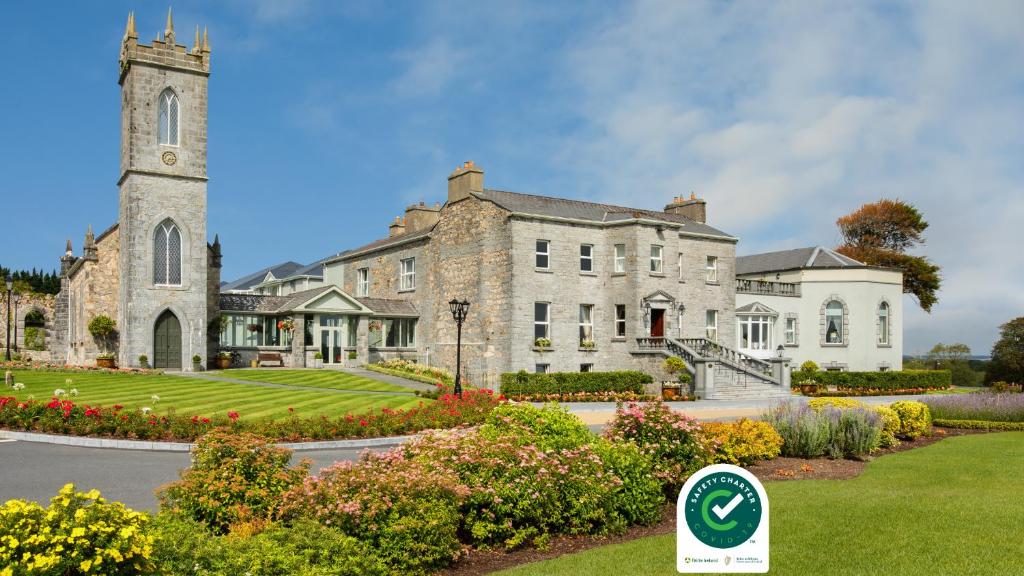 a large stone building with a clock tower at Glenlo Abbey Hotel in Galway