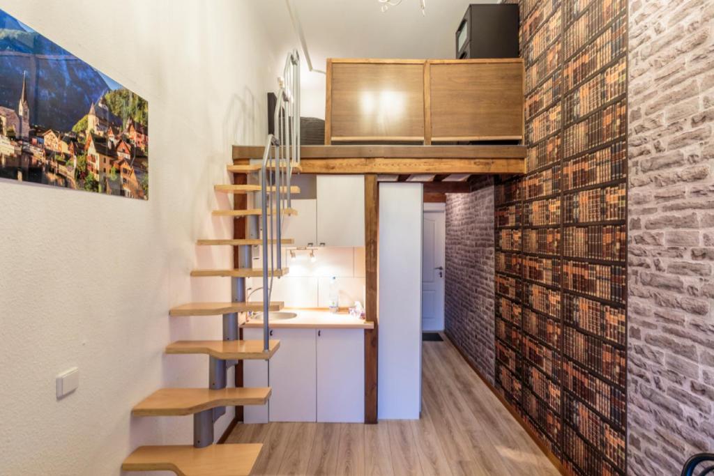 a loft apartment with a staircase and a brick wall at K&S Apartments in Berlin