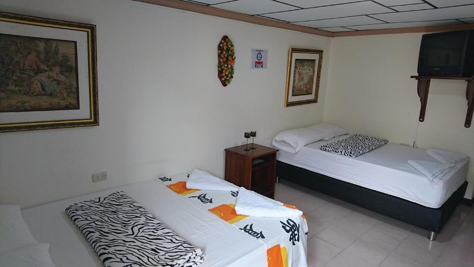 a room with two beds and a television in it at Apartamento Rosita in Jardin