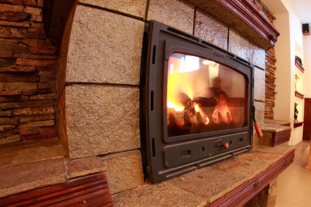 a television in a brick wall with a fire in it at Hotel Akre in Kavarna