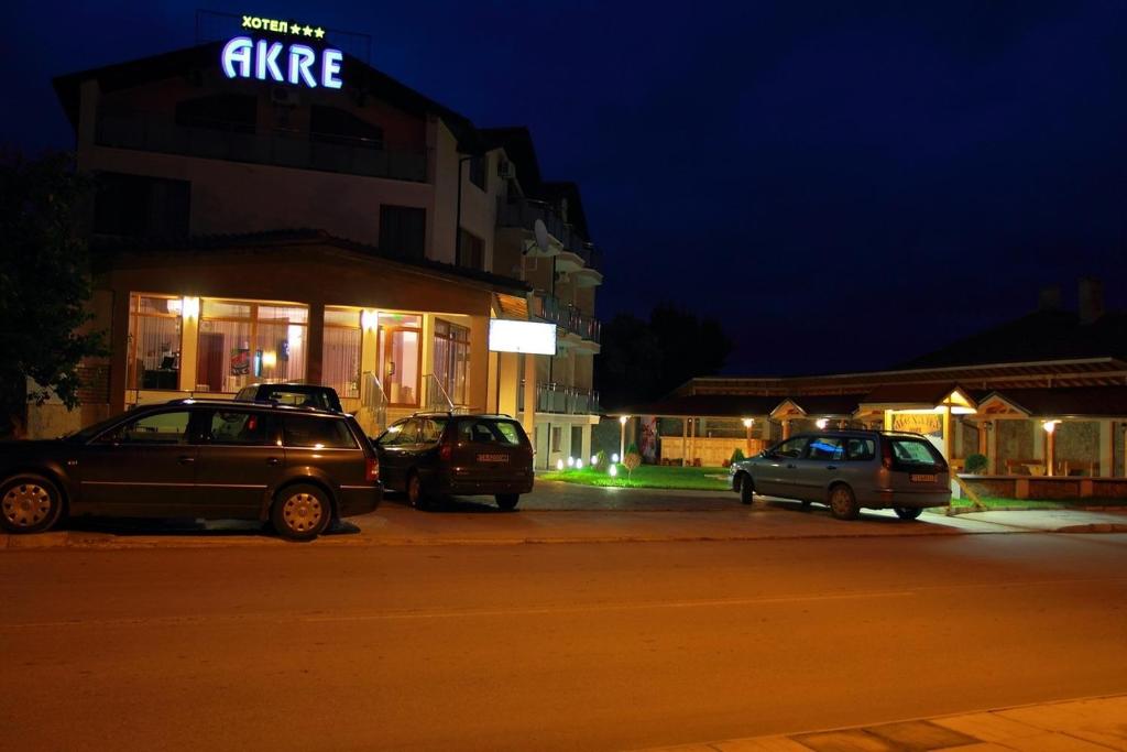 two cars parked in front of a building at night at Hotel Akre in Kavarna
