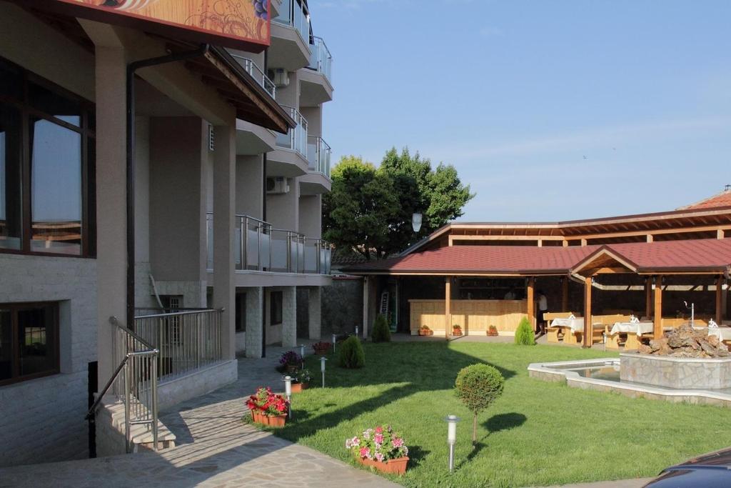 a courtyard of a building with a yard with flowers at Hotel Akre in Kavarna
