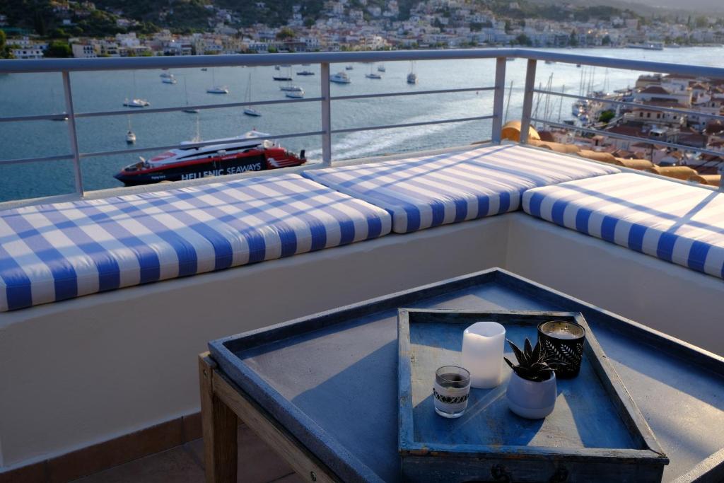 un balcón con 2 bancos y una mesa en un barco en 180° view maisonette No.1 en Poros