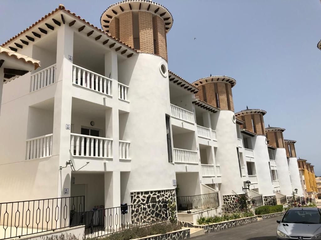 un edificio con balconi e una macchina parcheggiata di fronte di Hillasol vakantiewoning El Pinet Beach a La Marina