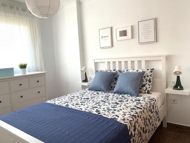 a bedroom with a blue and white bed with blue pillows at UIM Mediterraneo Diagonal 17 Wifi in Puerto de Sagunto