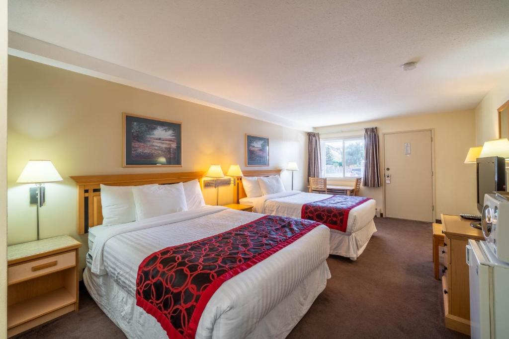 a hotel room with two beds and a television at Canada's Best Value Desert Inn & Suites in Cache Creek