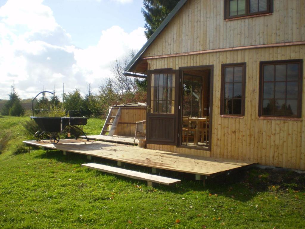a small house with a deck and a grill at Auru Cīruļi in Auri