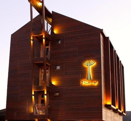 a building with a tree on the side of it at Rangi Pucon in Pucón