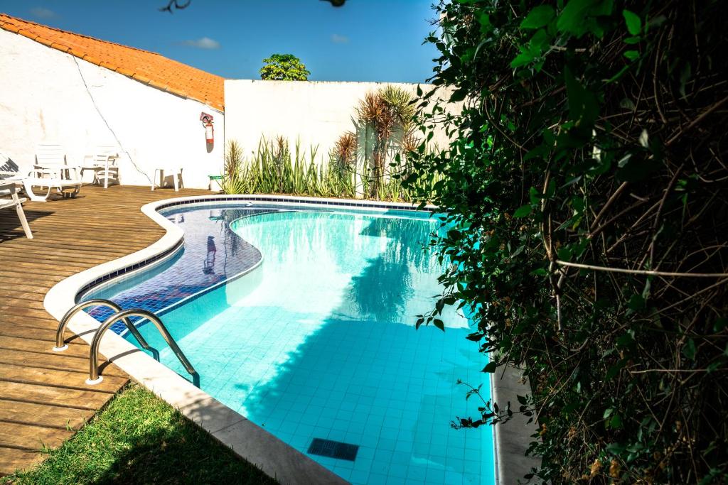 een zwembad naast een houten terras bij Pousada dos Quatro Cantos in Olinda