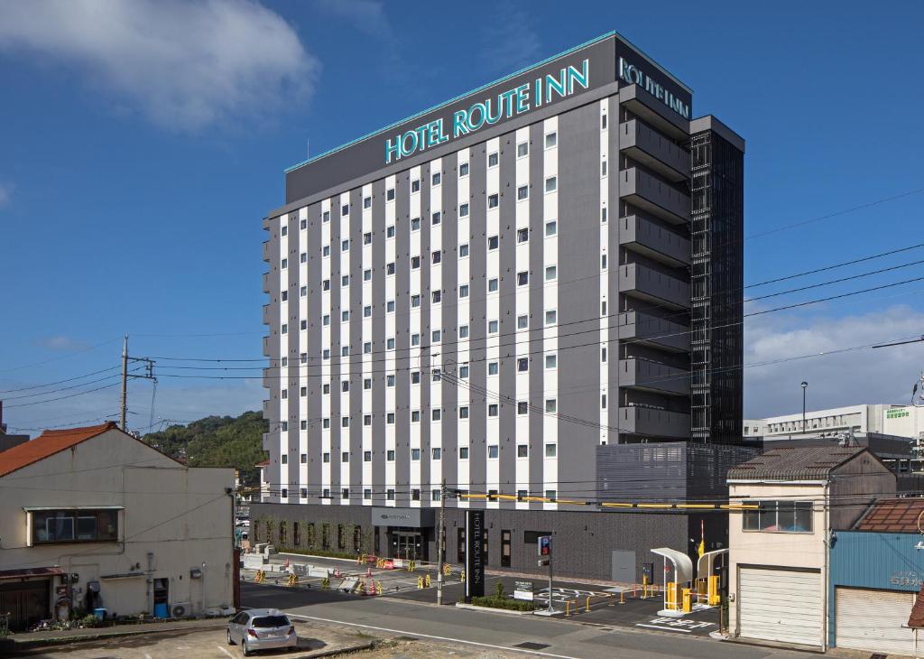 a large white building with a sign on it at Hotel Route-Inn Hamada Ekimae in Hamada