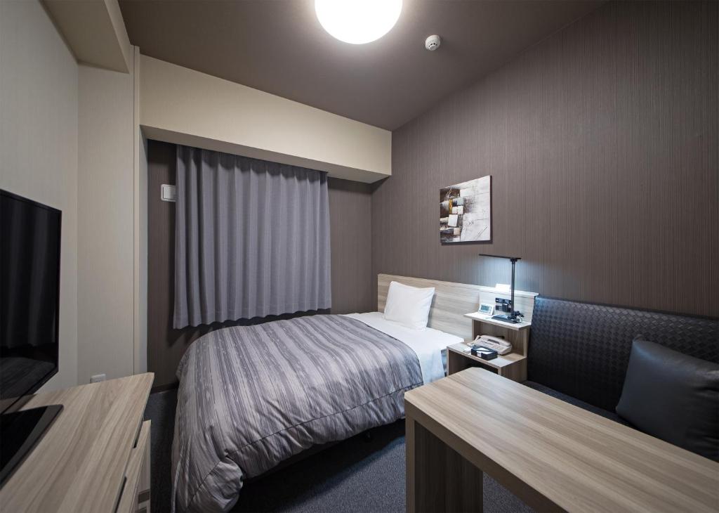 Postel nebo postele na pokoji v ubytování Hotel Route-Inn Hamada Ekimae
