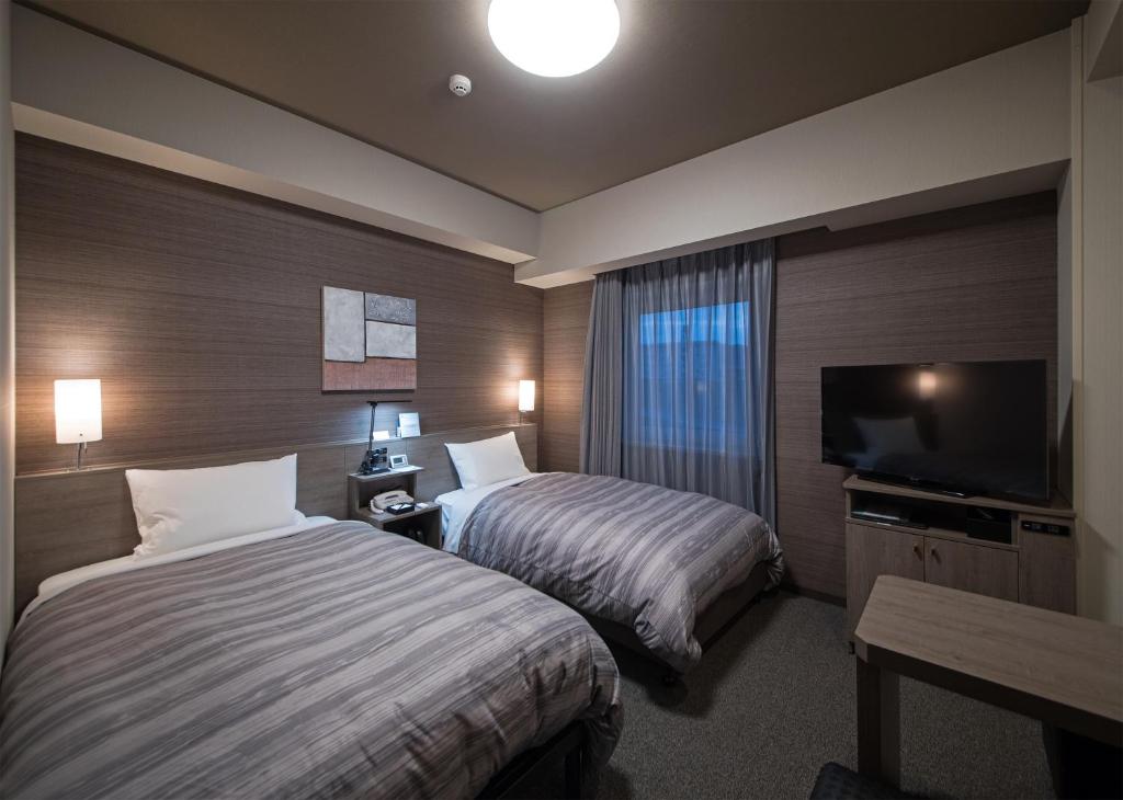 Postel nebo postele na pokoji v ubytování Hotel Route-Inn Hamada Ekimae