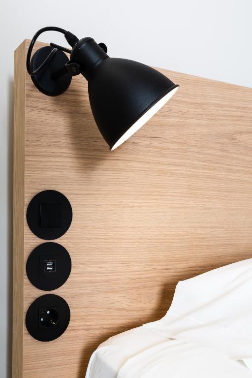 a black lamp on the headboard of a bed at Gallery Hostel in Porto