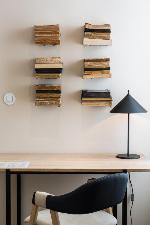 a desk with a black lamp and a chair at Gallery Hostel in Porto