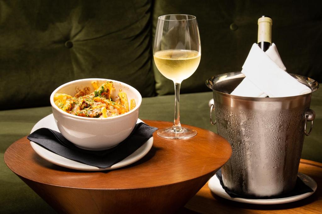 a table with a bowl of food and a glass of wine at Gallery Hostel in Porto
