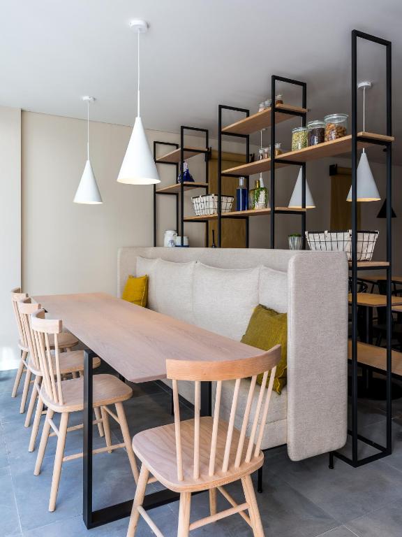 a dining room with a table and chairs and a couch at Gallery Hostel in Porto