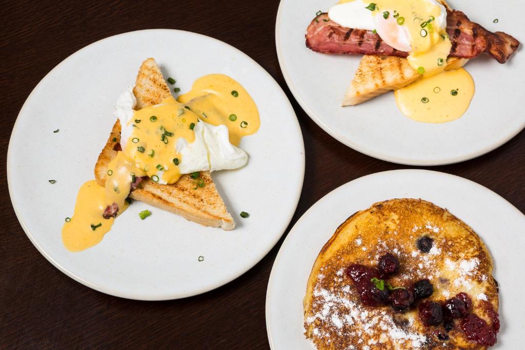 three plates of breakfast food on a table at Gallery Hostel in Porto