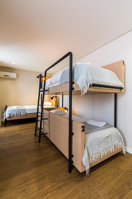 a room with two bunk beds and a ladder at Gallery Hostel in Porto