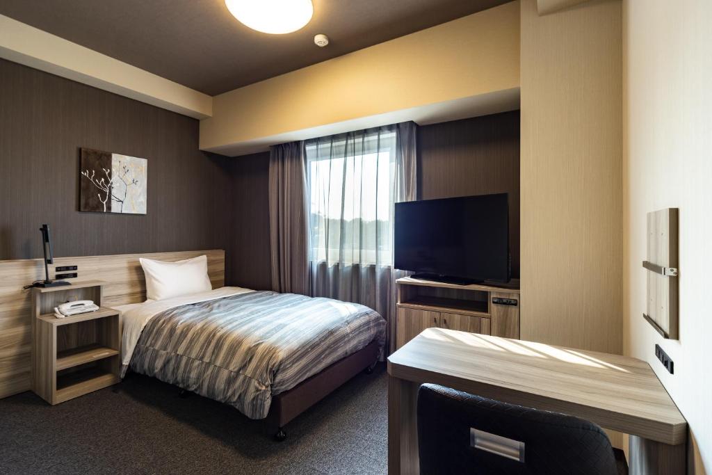 Postel nebo postele na pokoji v ubytování Hotel Route-Inn Kashiwa Minami -Kokudo 16Gouzoi-