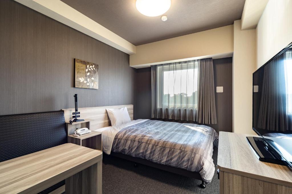 Postel nebo postele na pokoji v ubytování Hotel Route-Inn Kashiwa Minami -Kokudo 16Gouzoi-