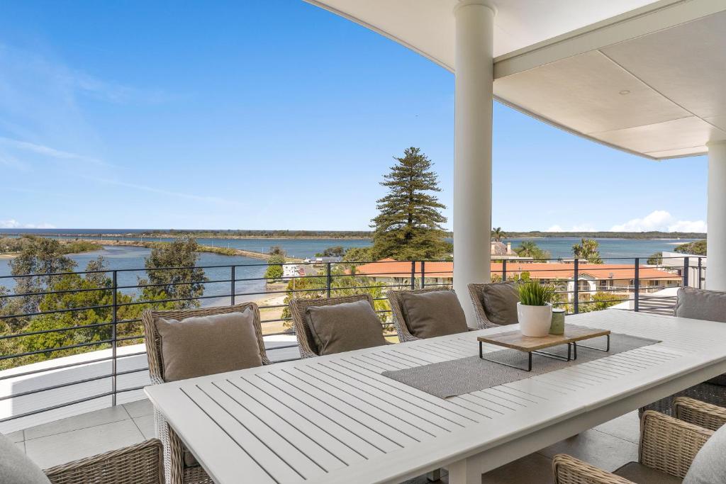 a table and chairs on a balcony with a view of the water at Shawhaven in East Ballina
