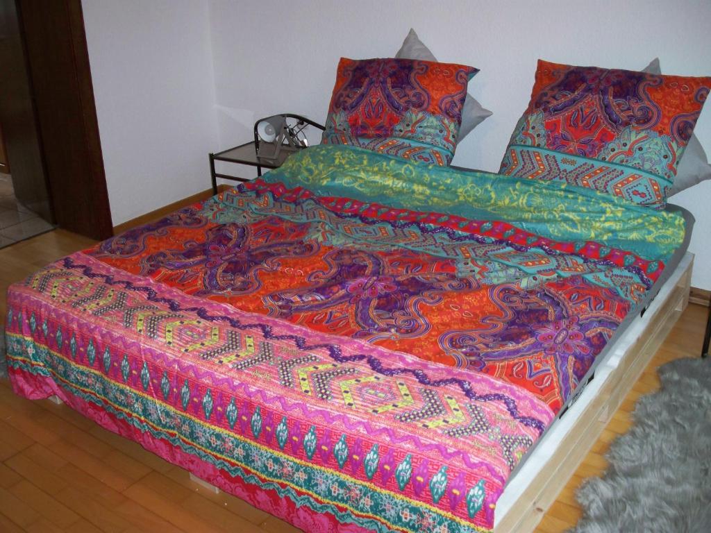 a bed with a colorful blanket and pillows on it at 2 Raum Wohnung in Krefeld
