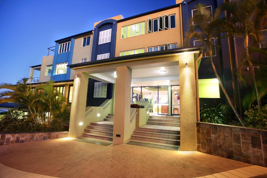 a large building with a front door with a staircase at Caloundra Central Apartment Hotel Official in Caloundra