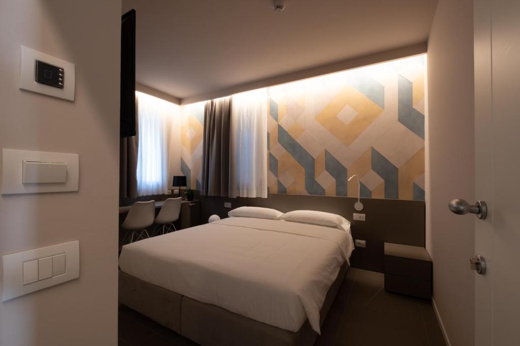 Un dormitorio con una cama blanca y una pintura en la pared en Zeta T Rooms, en Castellarano