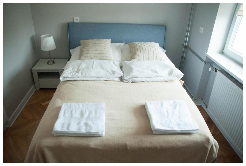 a bed with two towels sitting on top of it at Color 24 Apartament III in Stalowa Wola