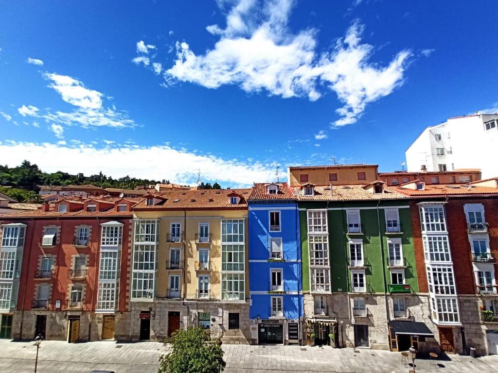 a row of colorful buildings in a city at La casa de LA FLORA a 3 minutos de la catedral VUT09187 in Burgos