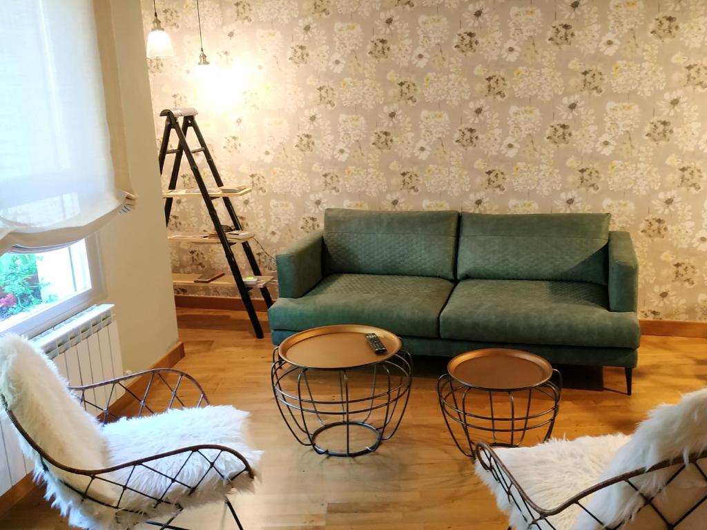 a living room with a green couch and chairs at El Bordon in Arguedas