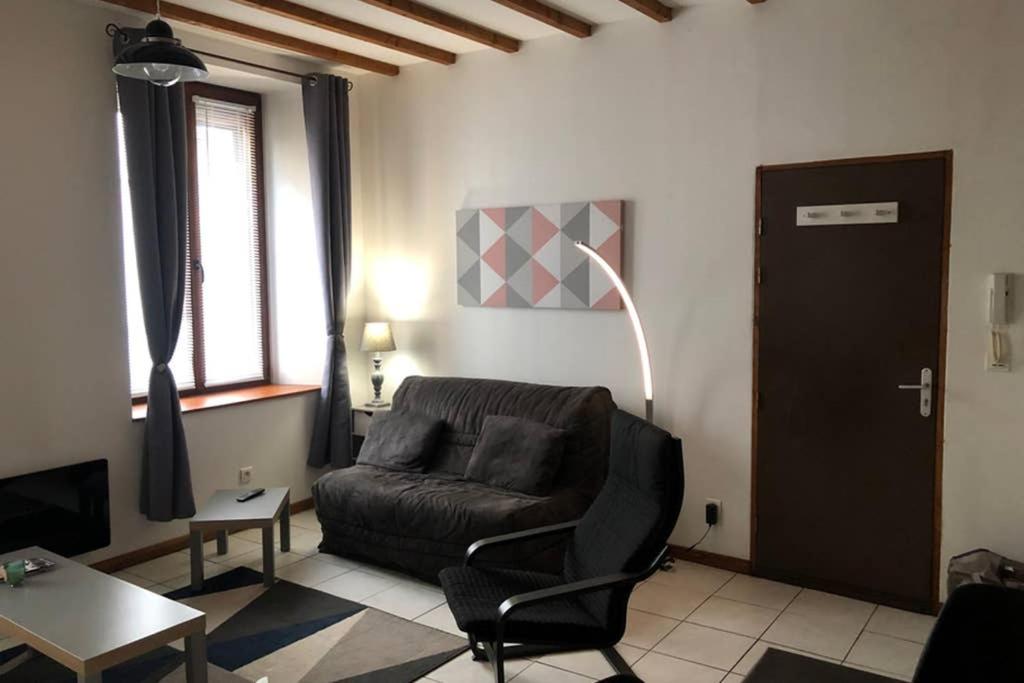 een woonkamer met een leren stoel en een tafel bij F2 Saint Lambert Verdun in Verdun-sur-Meuse