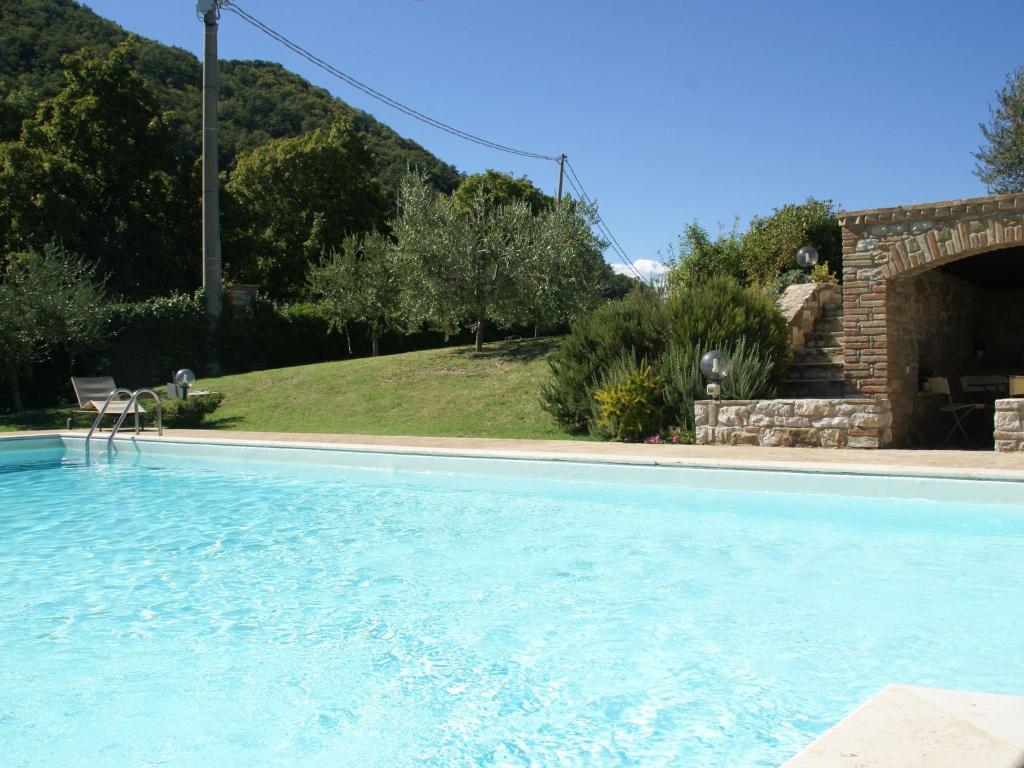 a large swimming pool in a yard with a mountain at Belvilla by OYO Villa Monte Acuto in Galera