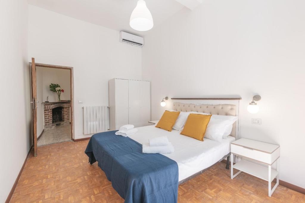 um quarto com uma grande cama branca e um cobertor azul em Vicolo del Cinque Apartment Trastevere em Roma