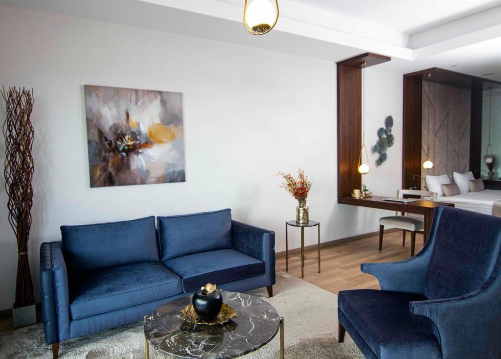 a living room with two blue couches and a table at Maslak Aparts in Istanbul